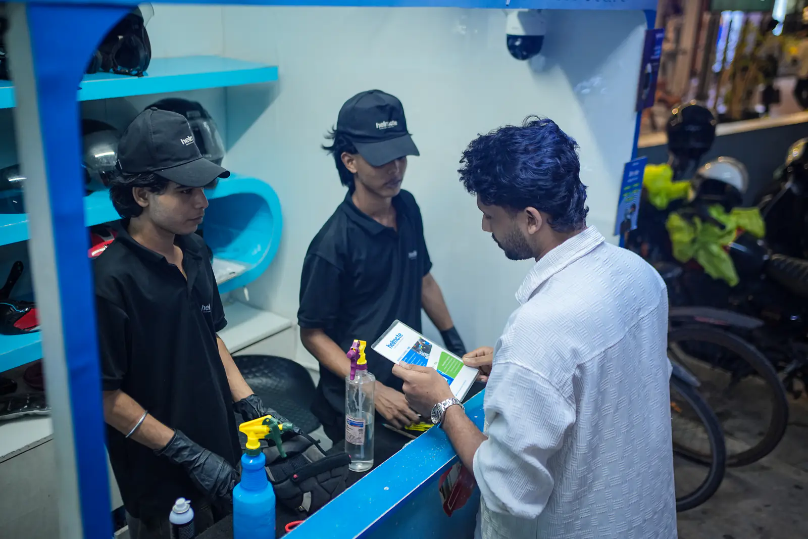 A Helmate technician talking a rider through the cleaning options at the counter