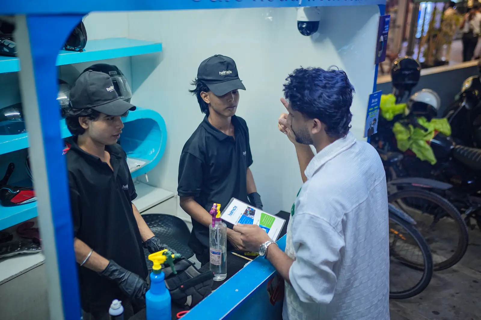 Helmate crew explaining the service to a customer at the front desk