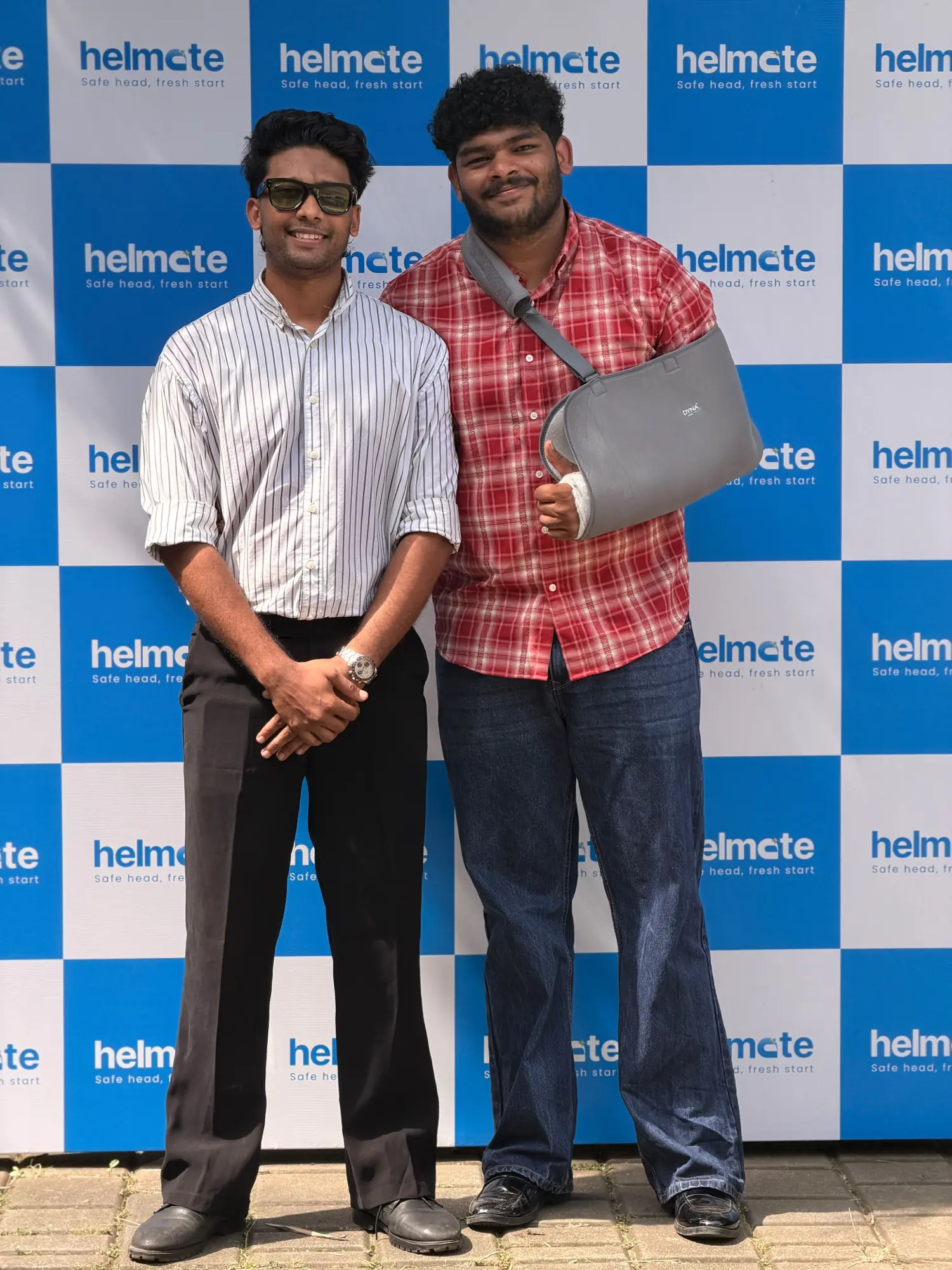 Two Helmate team members at the branded backdrop