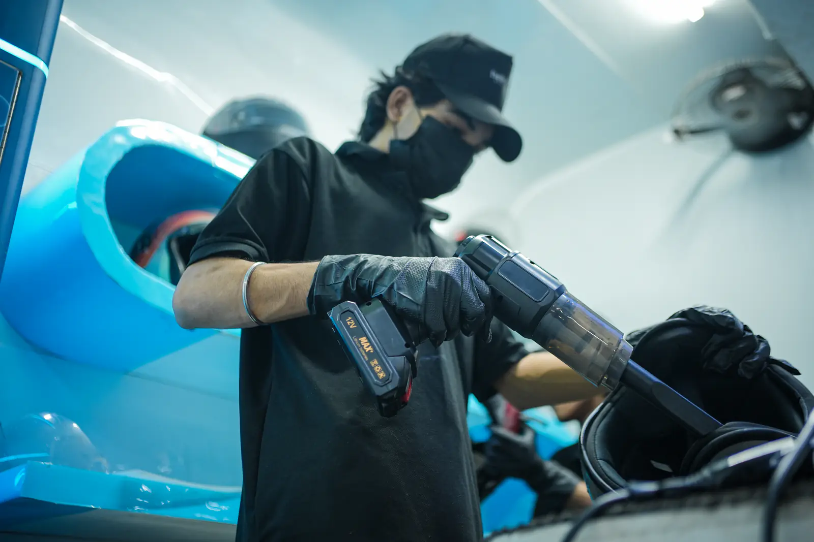 A technician driving compressed air through a helmet to clear water and debris