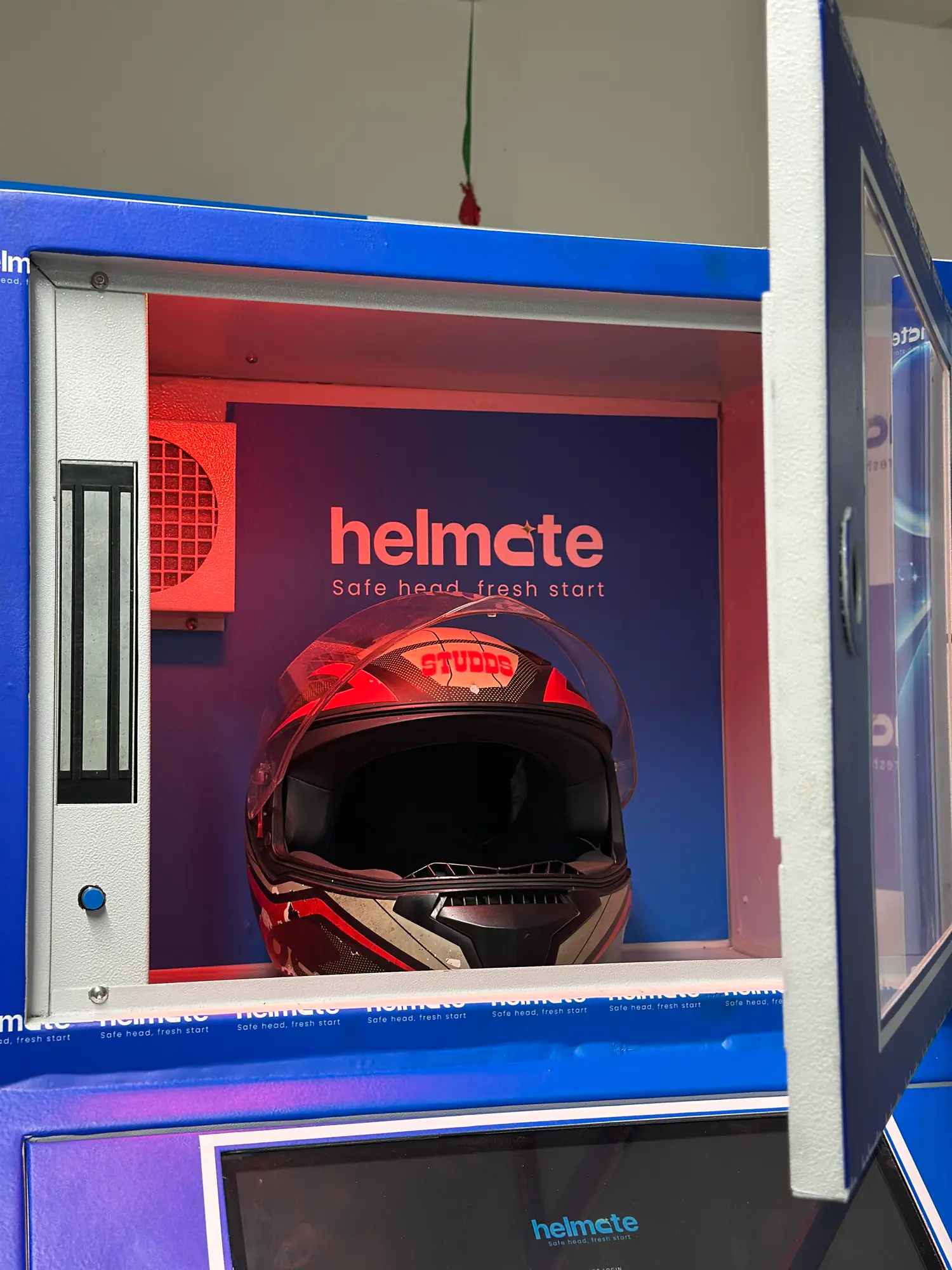 A full-face helmet seated inside the lit Helmate sterilization chamber